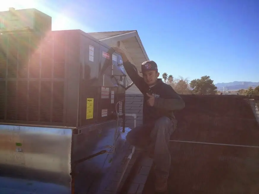 HVAC technician performing Heat Pump Repair on a rooftop unit in Canton